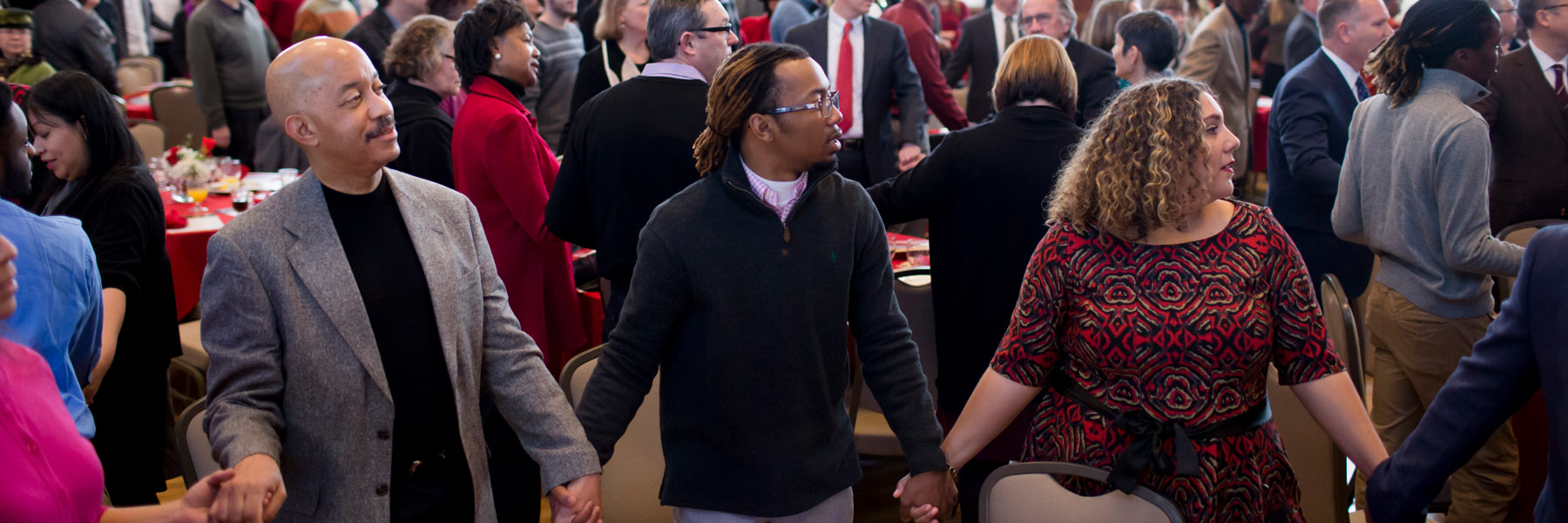 Attendees hold hands during a Martin Luther King Jr. Day celebration.